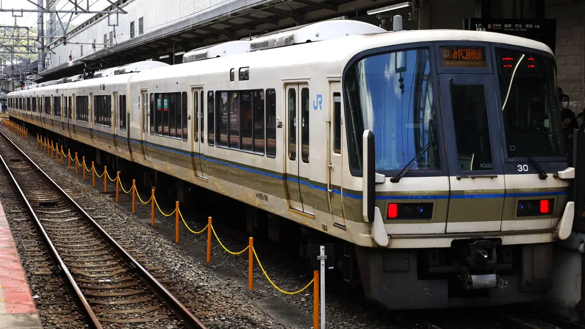 A cream and blue JR commuter train waiting at a platform at Kyoto Station