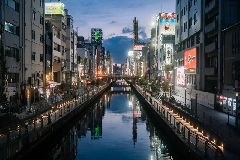 The Dotonbori canal in Osaka at night with bright signs reflected in the water