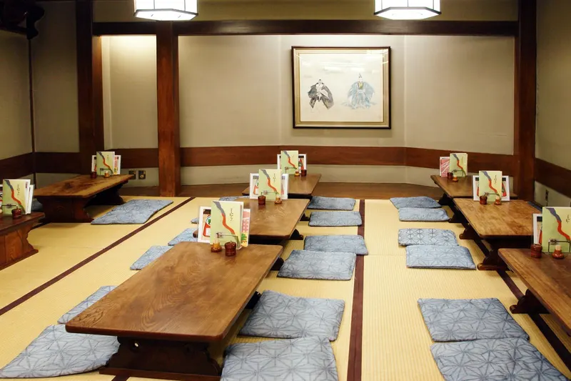 A tatami room in a Japanese ryokan set with low wooden tables and floor cushions