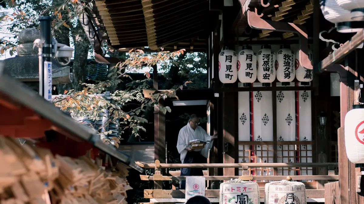 Stone lanterns and visitors at a shrine in Kyoto