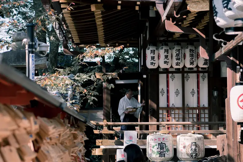 Stone lanterns and visitors at a shrine in Kyoto