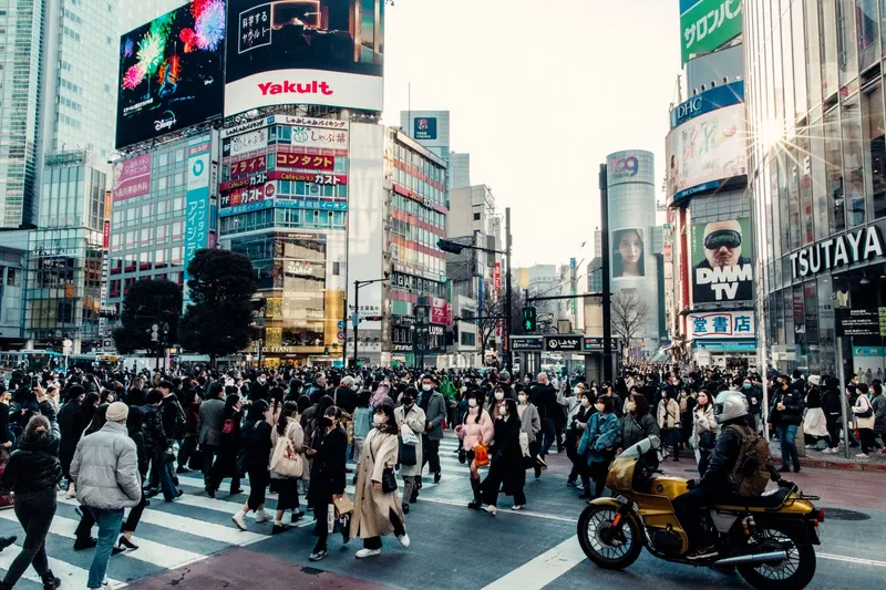 Crowds crossing the Shibuya scramble crossing in Tokyo in daylight